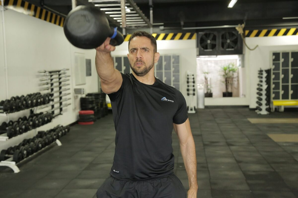 Athlete training with a kettlebell, preparing for HYROX rules and movement standards